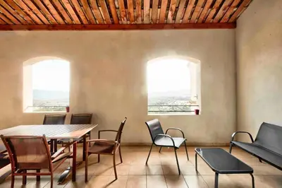 a dining room with a table and chairs and two windows at Les Coteaux de Pont Royal en Provence - maeva Home - Appartement 3 Pièces 6 Personnes - Sélection MAE-5989 in Mallemort