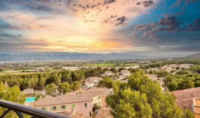 a view of a town at sunset from a house at Les Coteaux de Pont Royal en Provence - maeva Home - Appartement 3 Pièces 6 Personnes - Sélection MAE-5989 in Mallemort