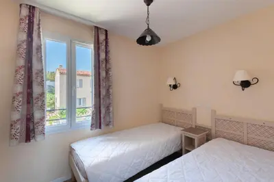 two beds in a room with a window at Les Coteaux de Pont Royal en Provence - maeva Home - Maison 3 Pièces 6 Personnes - Sélection MAE-7944 in Mallemort