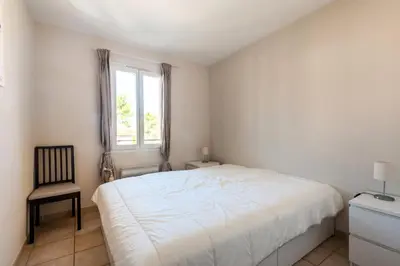 a bedroom with a bed and a chair and a window at Village Pont Royal en Provence - maeva Home - Maison de charme climatisée 4 pièces 8 personnes - Sélection - super Home MAE-7694 in Mallemort