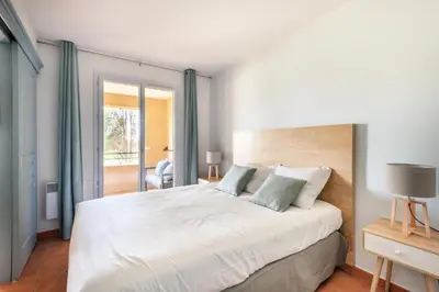a bedroom with a large white bed with blue curtains at Résidence Hôtel du Golf de Pont Royal - maeva Home - Appartement climatisé ravissant 2 pièces 4 personnes - Prestige - super Home MAE-3104 in Mallemort