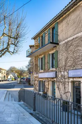 a building with a fence next to a street at La Terrasse d'Eygalières in Eygalières