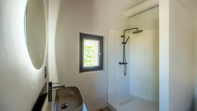 a white bathroom with a sink and a shower at La Terrasse d'Eygalières in Eygalières