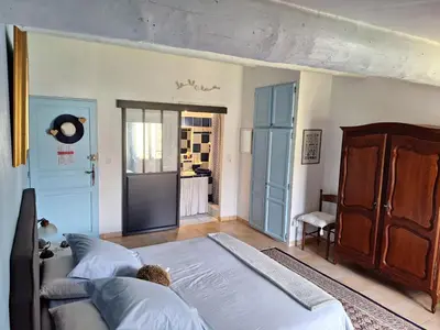 a bedroom with a bed with a teddy bear on it at Clos des Hérissons - Chambres d'Hôte - Piscine & jardin in Lauris