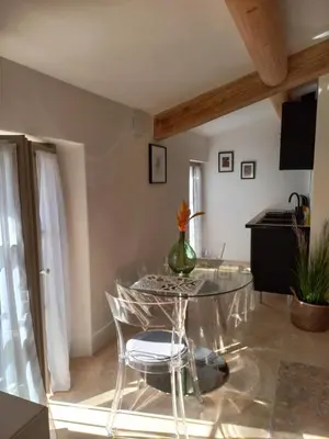 a dining room with a glass table and chairs at Le Mas Joséphine in Saint-Rémy-de-Provence