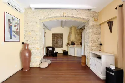 a living room with a brick wall and a vase at Maison de Charme au Pays de Cézanne in Aix-en-Provence