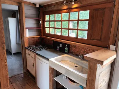 a kitchen with a sink and a stove at Chalet banane devant piscine, a 6km du festival de piano de la roque d'anthéron in Rognes