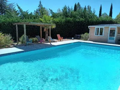 a large blue swimming pool with a gazebo at Chalet banane devant piscine, a 6km du festival de piano de la roque d'anthéron in Rognes