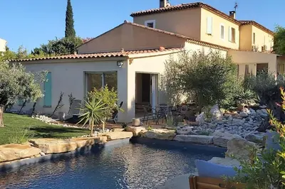 a house with a pond in front of a house at Une Oasis au Pays de Cézanne in Aix-en-Provence