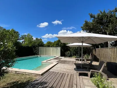 a swimming pool with an umbrella and chairs and a table with an umbrella at Mas de l'Estiou in Monteux