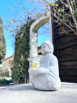 a statue of a child holding a bowl with a flower at Mas de l'Estiou in Monteux