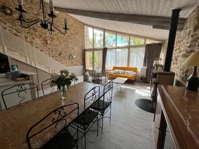 a living room with a dining table and chairs at Mas de l'Estiou in Monteux