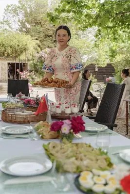 a woman standing in front of a table with food at Mas de l'Estiou in Monteux