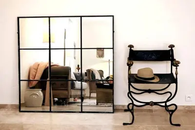 a room with a mirror and a chair with a hat at La Borie Oubliée in Gordes