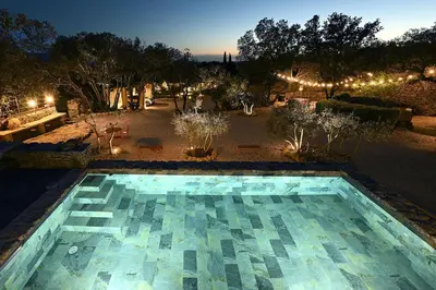 a swimming pool in the middle of a yard at night at La Borie Oubliée in Gordes