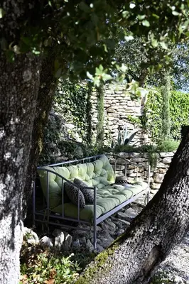 a bench sitting under a tree in a garden at La Borie Oubliée in Gordes