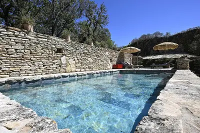 a large swimming pool in a stone wall at La Borie Oubliée in Gordes