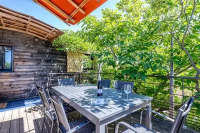 a white table and chairs on a deck with trees at campdebaseventoux, vue sur le ventoux insolite in Bédoin