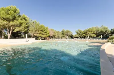a swimming pool with people in the water at Les Maisons de Pont Royal en Provence - maeva Home - Maison 3 pièces 6 personnes - Sélection MAE-1676 in Mallemort