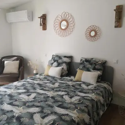 a bedroom with a bed with a blue and white blanket at Le Mas Paolo in Le Thor