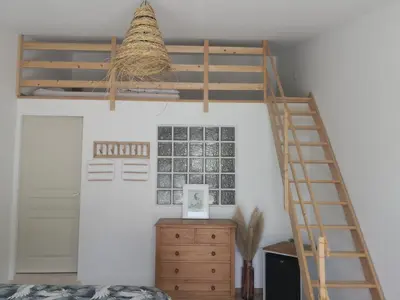a bedroom with a loft bed and a desk at Le Mas Paolo in Le Thor