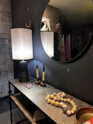 a room with a table with a lamp and a mirror at La Suite TAMAN au centre de Salon in Salon-de-Provence