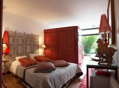 a bedroom with a bed with a red headboard at Le Clos des Amandiers in Simiane-la-Rotonde