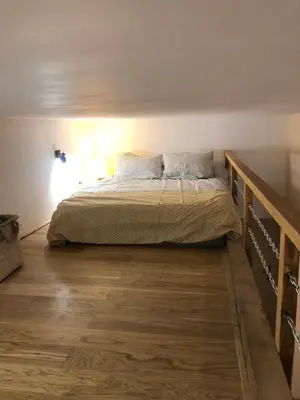 a bedroom with a bed and a wooden floor at Les Remparts de Lauris Coeur Médiéval et Patio in Lauris