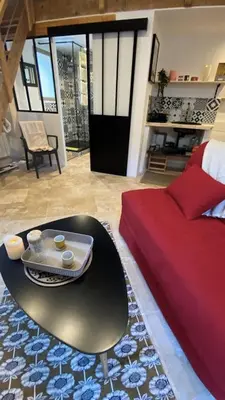 a living room with a bed and a table at Les Remparts de Lauris Coeur Médiéval et Patio in Lauris