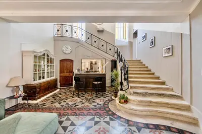 a living room with a staircase and a table at La Chapelle sur la Sorgue in LʼIsle-sur-la-Sorgue