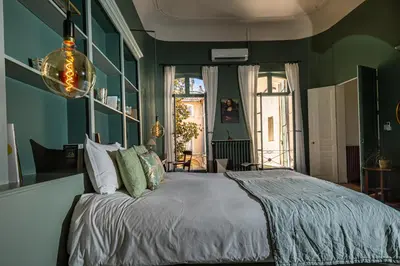 a bedroom with green walls and a large bed at La Chapelle sur la Sorgue in LʼIsle-sur-la-Sorgue