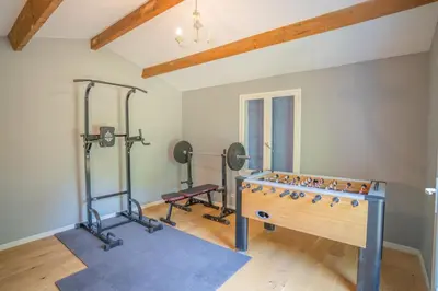 a room with a gym with a foos ball and weights at Maison des lavandes in Saint-Cannat