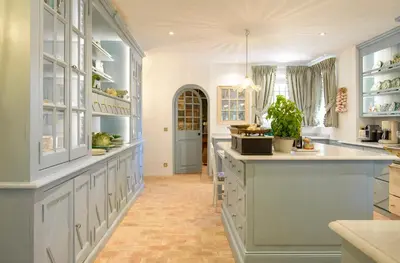 a large kitchen with white cabinets and a large island at Le Clos des Rosiers in Gordes