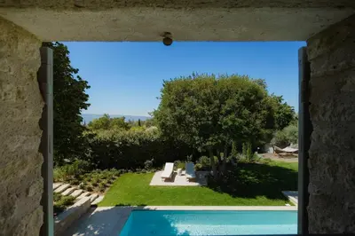 a view of a garden through a window at Le Clos des Rosiers in Gordes