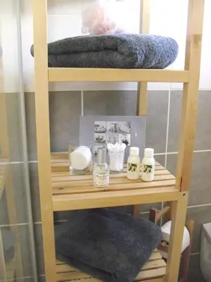 a wooden shelf with towels and other items on it at Studio à Deux Pas d'Aix in Aix-en-Provence
