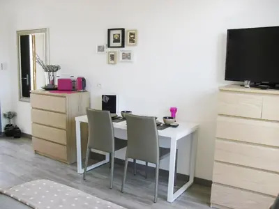a dining room with a white table and chairs at Studio à Deux Pas d'Aix in Aix-en-Provence