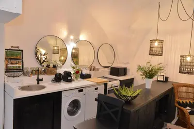 a bathroom with a washing machine and a sink at La BARBELLA in Lourmarin