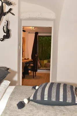 a bedroom with a bed and a dining room at La BARBELLA in Lourmarin