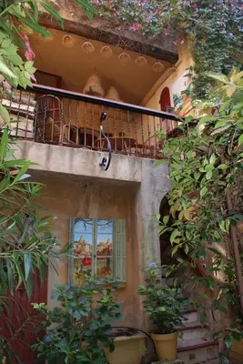 a balcony on the side of a building with plants at La BARBELLA in Lourmarin