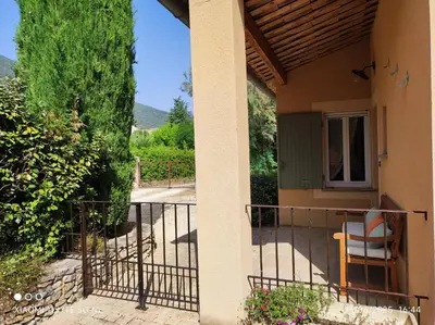 a porch of a house with a chair on it at GITE AUX 4 SAISONS DU COLORADO PROVENÇAL - 3 ÉTOILES - Rustrel in Rustrel
