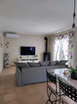 a living room with a couch and a tv at GITE AUX 4 SAISONS DU COLORADO PROVENÇAL - 3 ÉTOILES - Rustrel in Rustrel