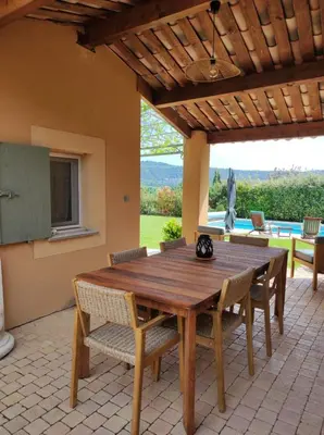 a wooden table and chairs on a patio at GITE AUX 4 SAISONS DU COLORADO PROVENÇAL - 3 ÉTOILES - Rustrel in Rustrel