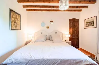 a bedroom with a large white bed with two lamps at Joli mas 