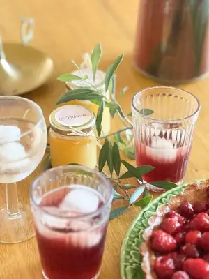 a table with a plate of food and glasses of drinks at La Bohème à Lacoste in Lacoste