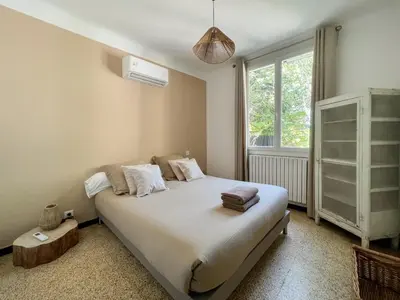 a bedroom with a bed and a window at La Bohème à Lacoste in Lacoste