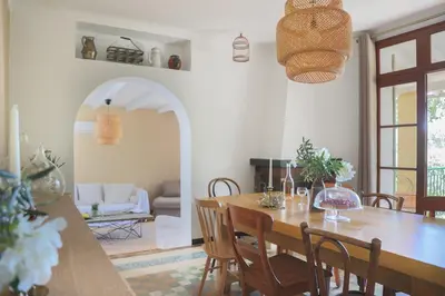 a dining room with a wooden table and chairs at La Bohème à Lacoste in Lacoste