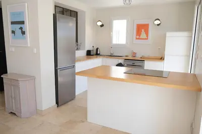 a kitchen with a refrigerator and a wooden counter top at nice house with private pool - 6 persons in the center of the village of mérindol in the luberon in provence in Mérindol