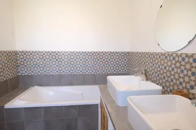 a bathroom with two sinks and a tub and a mirror at nice house with private pool - 6 persons in the center of the village of mérindol in the luberon in provence in Mérindol