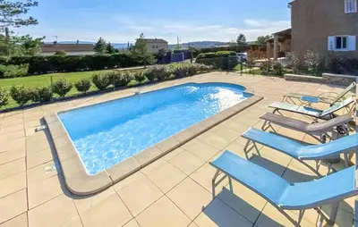 a swimming pool with chairs and a swimming pool at 3 Bedroom Gorgeous Home In Gargas in Gargas