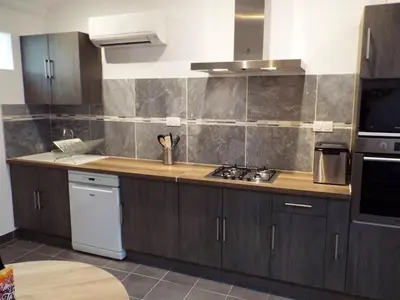 a kitchen with wooden cabinets and a counter top at Appartement charmant à Avignon, 45 m² avec piscine partagée in Avignon